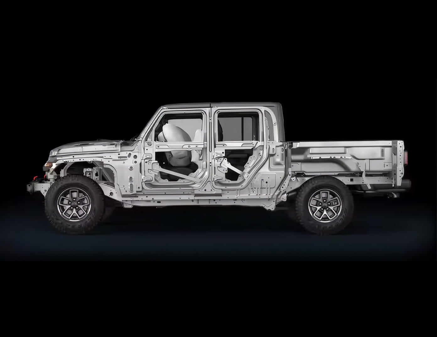 Side view of a Jeep Gladiator body structure and frame displayed against a black background.